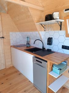 a kitchen with a sink and a counter top at Tiny Chaumière - Escapade Romantique - Chaumière et Jacuzzi Privatif proche Pont-Aven in Riec-sur-Bélon +9 photos