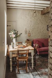 a living room with a table and a red couch at Ty Bach in Llanwrtyd Wells
