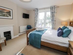 a bedroom with a bed and a fireplace at Tyddyn Goronwy in Dyffryn