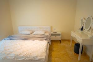 a bedroom with a bed and a desk and two mirrors at RMR Luxury Apartaments in Timişoara