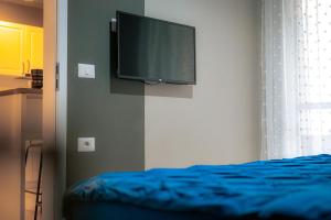 a bedroom with a flat screen tv on the wall at RMR Luxury Apartaments in Timişoara
