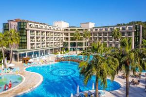 a resort with a large swimming pool and palm trees at Alder Resort Hotel -Ultra All Inclusive in Kemer