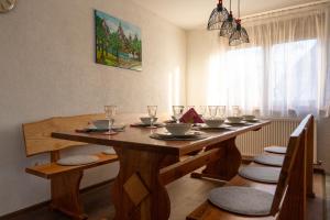 a dining room table with chairs and a wooden table with glasses at Kuća za odmor Marija in Gospić
