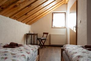 a bedroom with two beds and a table and a window at Kuća za odmor Marija in Gospić