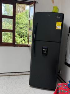 a black refrigerator in a room with a window at ecopolis birds lodge in El Queremal