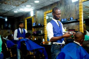 a group of men in a barber shop at El-Nido Hotel by Kdove in Omole