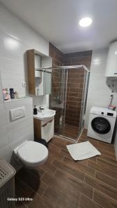 a bathroom with a toilet a sink and a shower at Apartman Mima in Inđija