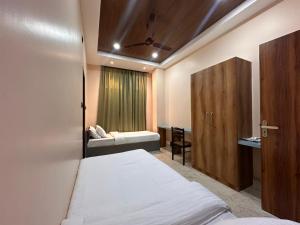 a bedroom with a bed and a door and a window at Hotel Maple Lawn in Guwahati