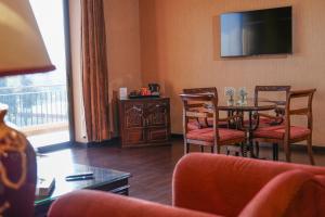 a living room with a table and chairs and a television at Chtaura Park Hotel in Chtaura