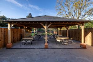 a wooden pavilion with tables and chairs on a patio at The Horns Pub - Crazies Hill in Hurley