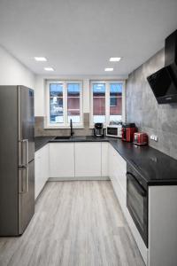 a large kitchen with white cabinets and black appliances at Wonderful Dream Apartament z widokiem na Śnieżkę in Karpacz