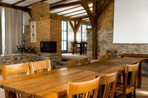 a large wooden table and chairs in a room with a fireplace at Ferma de Biodiversitate COBOR in Cobor