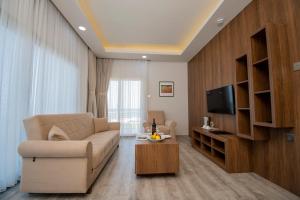a living room with a couch and a tv at Mimoza Beach Hotel in Yenibosazici
