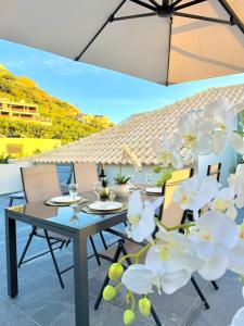 a table and chairs on a patio with white flowers at Refúgio do Vale Verde in Ponta do Sol