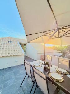 a dining room with a table with chairs and an umbrella at Refúgio do Vale Verde in Ponta do Sol