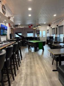 a room with a pool table and tables and chairs at St Olaf Golf Hotel in Cruden Bay