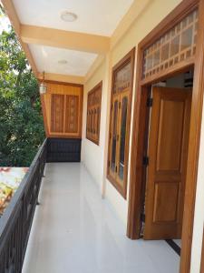 a corridor of a house with wooden doors at Mahizh Manai in Jaffna