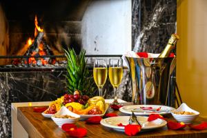 a table with glasses of champagne and food and a fireplace at Mimoza Beach Hotel in Yenibosazici