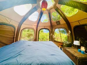 a bedroom with a bed in a tent with windows at Casita Orquidea in Resolution