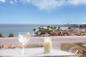 a glass of wine on a table with a view of the ocean at Aluasun Lago Rojo - Adults recommended in Torremolinos +57 photos