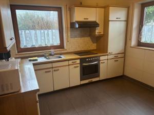a kitchen with a sink and a stove top oven at Panoramaferienwohnungen Stemler in Eulenbis