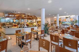 a restaurant with tables and chairs and a counter at Aluasun Lago Rojo - Adults recommended in Torremolinos