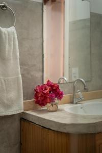 a bathroom with a sink and a vase of flowers at casa jasmin in Jericoacoara +90 photos