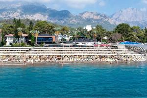 a beach with a bunch of umbrellas in the water at Alder Resort Hotel -Ultra All Inclusive in Kemer
