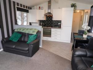 a kitchen with a couch and a chair and a table at Harper's Hideaway in Morpeth