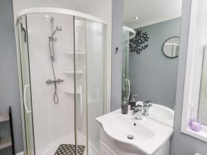 a white bathroom with a shower and a sink at Harper's Hideaway in Morpeth +16 photos