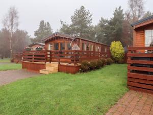 a large wooden house with a green yard at Chloe's Cabin in Morpeth