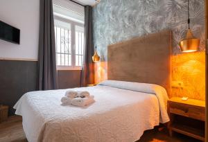 a bedroom with a bed with two teddy bears on it at Hostal La Muralla in Seville +48 photos