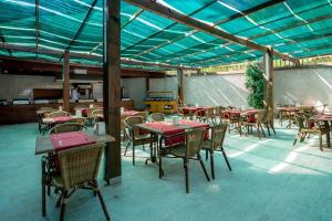 a restaurant with tables and chairs and a roof at Alder Resort Hotel -Ultra All Inclusive in Kemer