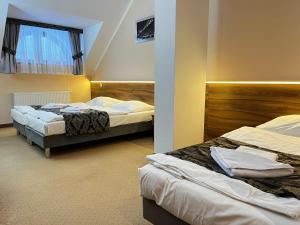 a bedroom with two beds and a window at Hotel Gorzelanny - basen , jacuzzi , sauna sucha, parowa w cenie pobytu! in Pokrzywna