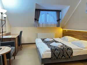 a hotel room with a bed and a table and chairs at Hotel Gorzelanny - basen , jacuzzi , sauna sucha, parowa w cenie pobytu! in Pokrzywna