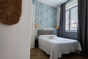 a bedroom with a bed and a blue wall at Hostal La Muralla in Seville