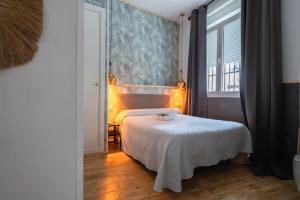 a bedroom with a bed and a large window at Hostal La Muralla in Seville