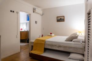 a bedroom with a bed with a yellow blanket on it at casa jasmin in Jericoacoara