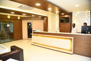 two men standing at a counter in a hotel lobby at Hotel Mars in Chennai