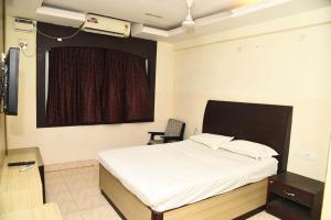 a bedroom with a white bed and a window at Hotel Mars in Chennai