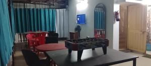 a living room with a table and a room with chairs at ROAMERS INN Backpackers Hostel in Kolkata