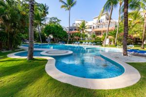 a swimming pool in a resort with palm trees at "Infinity Blue", Private Beach! in Sosúa