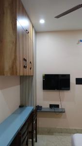 a kitchen with a blue counter and a tv on a wall at Hotel Maple Lawn in Guwahati