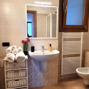 a bathroom with a sink and a mirror and towels at L'Antico Fienile Mountain Lake Iseo Hospitality in Fonteno