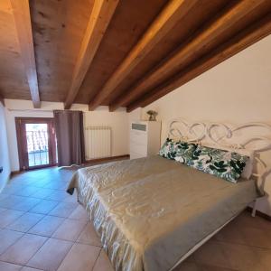 a bedroom with a large bed with a wooden ceiling at L'Antico Fienile Mountain Lake Iseo Hospitality in Fonteno