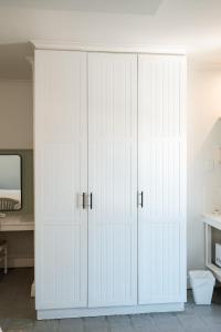 a white closet with white doors in a room at Summer House B&B in Gqeberha +120 photos