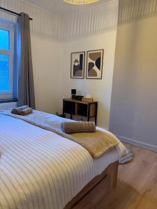 a bedroom with a bed with a table and a window at Loft by GIORGI - Centre de Bastogne in Bastogne