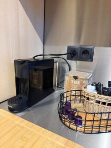 a counter top with a microwave and baskets on it at Loft by GIORGI - Centre de Bastogne in Bastogne