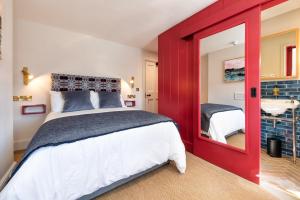 a red bedroom with a bed and a mirror at Ty'n Llan- tafarn gymunedol- community pub in Llandwrog