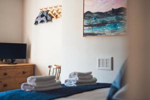 a bedroom with a bed with towels on it at Ty'n Llan- tafarn gymunedol- community pub in Llandwrog